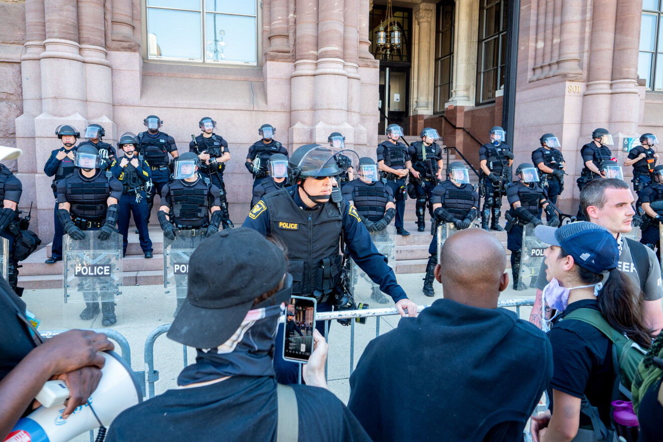 A Cincinnati officer interacts with demonstrators outside City Hall, June 2, 2020.